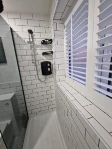 伯明翰Stylish 2 Bedroom Apartment Sleeps 4 Contractors and Corporates Welcome的带浴缸的浴室和窗户。