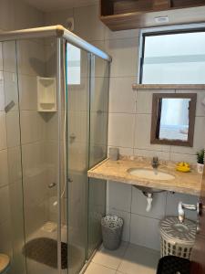 贝贝里比Apto 2 quartos - Condomínio Frente Mar的一间带玻璃淋浴和水槽的浴室