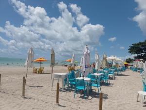 佩罗巴Casa morada da praia 5的一个带桌椅和遮阳伞的海滩