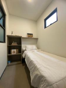 萨姆波罗Mely’s Tiny Home的一间小卧室,配有床和窗户
