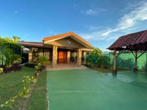 奎波斯城Casa Brisa Marina, Comfy Villa for 7 with Private Pool, Just 10 Minutes from Manuel Antonio!的前面有绿色车道的房子