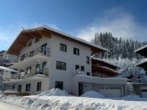 奥法赫Appartement Dorfblick的雪中的一个白色大房子