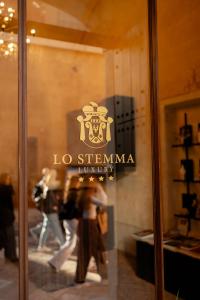 马泰拉Lo Stemma Luxury Boutique Hotel的商店窗口上的标志