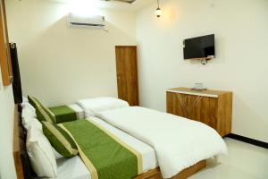 斋沙默尔The Travel Bug Jaisalmer的卧室配有一张床,墙上配有电视。