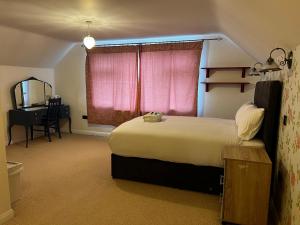 KentDartford Stay的一间卧室设有一张大床和粉红色的窗户