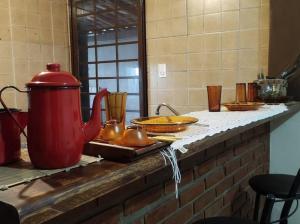 索罗卡巴Hospedagem San Gonzales Two的红色茶壶和盘子的柜台