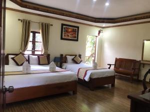 琅勃拉邦Xayana Home Villas的酒店客房,配有两张床和椅子