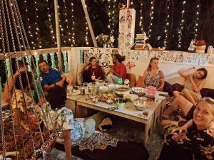 阿姆波尔Dreamcatcher House & Hostel at Arambol Beach的一群坐在桌子旁吃饭的人