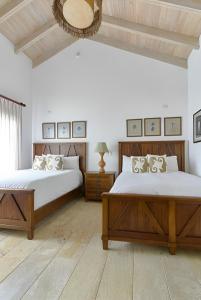 璜多里奥Majestuosa villa en Juan Dolio, Guavaberry Golf & Country Club的一间卧室配有两张床和镜子