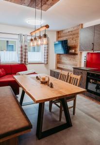 弗拉塔赫Ferienwohnung Sabine的厨房配有木桌和红色沙发。