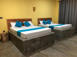 拉特纳普勒Palabaddala Tea and Eco Lodge的两张带蓝色枕头的床