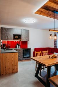 弗拉塔赫Ferienwohnung Sabine的厨房配有木桌和红色沙发。