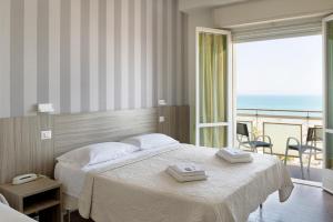 里米尼Hotel Centrale Miramare的一间卧室设有一张床,享有海景
