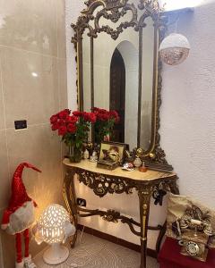 托雷奇安卡Ferienhaus am Meer Süd Italien Torre Chianca的梳妆台,配有镜子和红色玫瑰