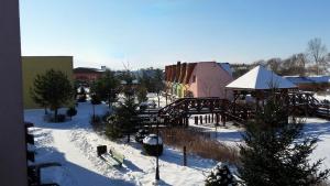 利普托斯基米库拉斯Tatralandia Apartmán的一座有积雪覆盖的城镇,有一座建筑和一座桥梁