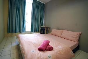 古晋Swanling Kuching的躺在床上的粉红色填充动物
