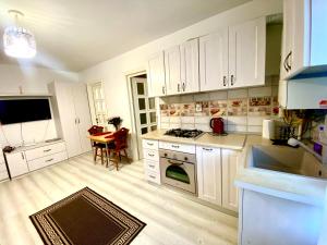 雅西Apartament Sara的厨房配有白色橱柜和桌子