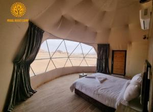 瓦迪拉姆Miral Night Camp的一间卧室设有一张床和一个大窗户
