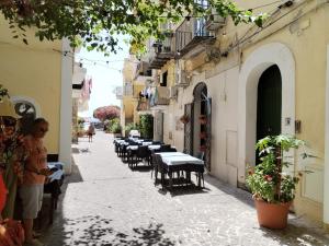 伊斯基亚Ischia Ponte romantic apartment in the historical center and near the sea的站在街上,拿着桌子和椅子的人