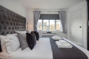 伦敦2 Bed town house with Garden in Hackney, London的卧室配有带枕头的大床和窗户。