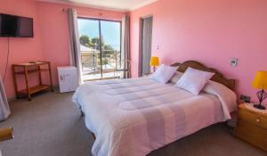 皮奇勒姆罗卡斯德尔太平洋酒店的卧室配有一张带粉红色墙壁的大床