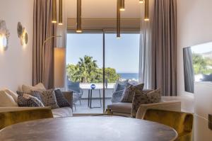 哈维亚Dionis Boutique Hotel & Spa的客厅配有桌子,享有海景