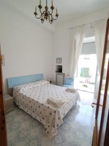 伊斯基亚Ischia Ponte romantic apartment in the historical center and near the sea的白色卧室配有一张床和一个吊灯