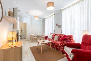 塞维利亚San Lorenzo en Esencia的客厅配有红色的沙发和桌子