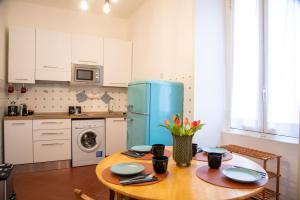 罗马Piazza Testaccio Home appartamento E 1 accogliente con vista piazza Testaccio的厨房配有桌子和蓝色冰箱。