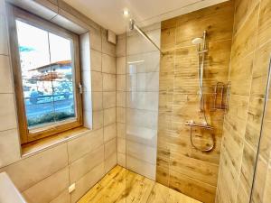 恩斯塔尔豪斯玛玛公寓式酒店的带淋浴的浴室和窗户。