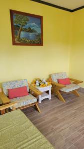 昂斯拉雷区Tropical Paradise View的一间设有两张长椅和一张桌子的房间,还有一幅画