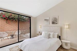 棕榈泉私人别墅管理公司圣丹斯别墅的卧室配有白色的床和砖墙