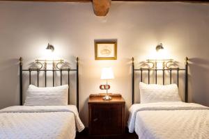 纳瓦孔塞霍拉富恩特德尔赫尔特乡村住宿加早餐旅馆的一间卧室配有两张床和一张带台灯的桌子