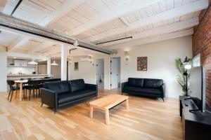 魁北克市Les Lofts de la Barricade - Par les Lofts Vieux-Québec的客厅配有黑色家具和桌子