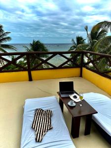 玛哈威鲁纳德普拉塔酒店的阳台配有桌子和床上的笔记本电脑