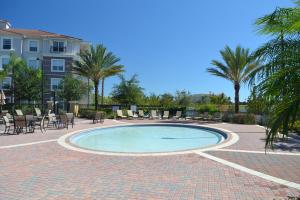 奥兰多Vista Cay Getaway Luxury Condo by Universal Orlando Rental的一个带桌椅的游泳池,棕榈树