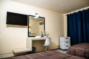 伊斯米基尔潘HOTEL DEL VALLE INN IXMIQUILPAN的一间带镜子、一张床和一张书桌的卧室