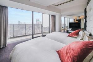 大阪和谐大使酒店的酒店客房设有两张床和大窗户。
