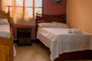 科潘玛雅遗址Residencia Sofmel的一间卧室设有两张床和窗户。