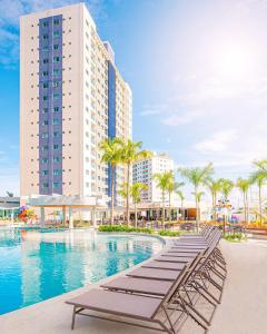 萨利诺波利斯Salinas Exclusive Resort的酒店游泳池设有躺椅,酒店大楼
