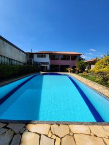 米格尔-佩雷拉Pousada Aconchego 2的一座房子前面的蓝色海水游泳池