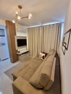 卡庞达卡诺阿Apto decorado e bem localizado的客厅配有大沙发和电视
