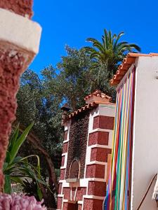 圣卢西亚Santa Lucía AgroRural的一座建筑,有五颜六色的围栏,背后有棕榈树