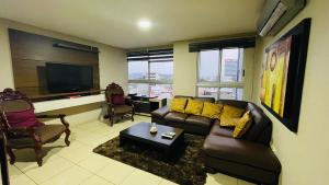 瓜亚基尔Five Stars Suites - Kennedy - Guayaquil的带沙发和电视的客厅