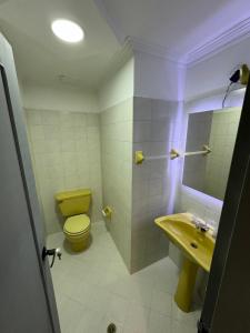 麦德林Rustik House的浴室设有黄色卫生间和水槽。