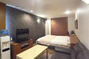 明石市ホテル タイムレス 明石 男塾ホテルグループ的小型酒店客房配有床和电视。