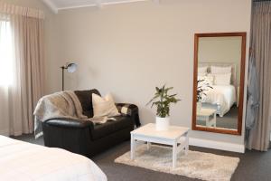 坎布里奇St Kilda Studio的一间卧室配有镜子、椅子和一张床