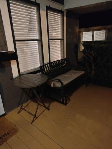 莱克兰Beautiful Mid Century Bungalow In The Heart of Lakeland的窗户间的长凳和桌子