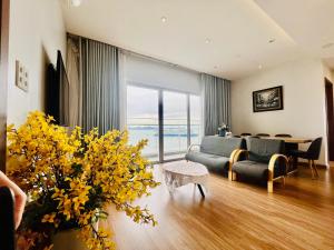 下龙湾Sapphire Residence Ha Long Luxury的客厅配有沙发和黄色花卉桌