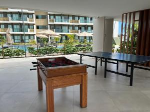 伊波茹卡Flat Mana Beach Pono 216 na Praia de Muro alto的两张乒乓球桌,位于一栋大楼的房间里